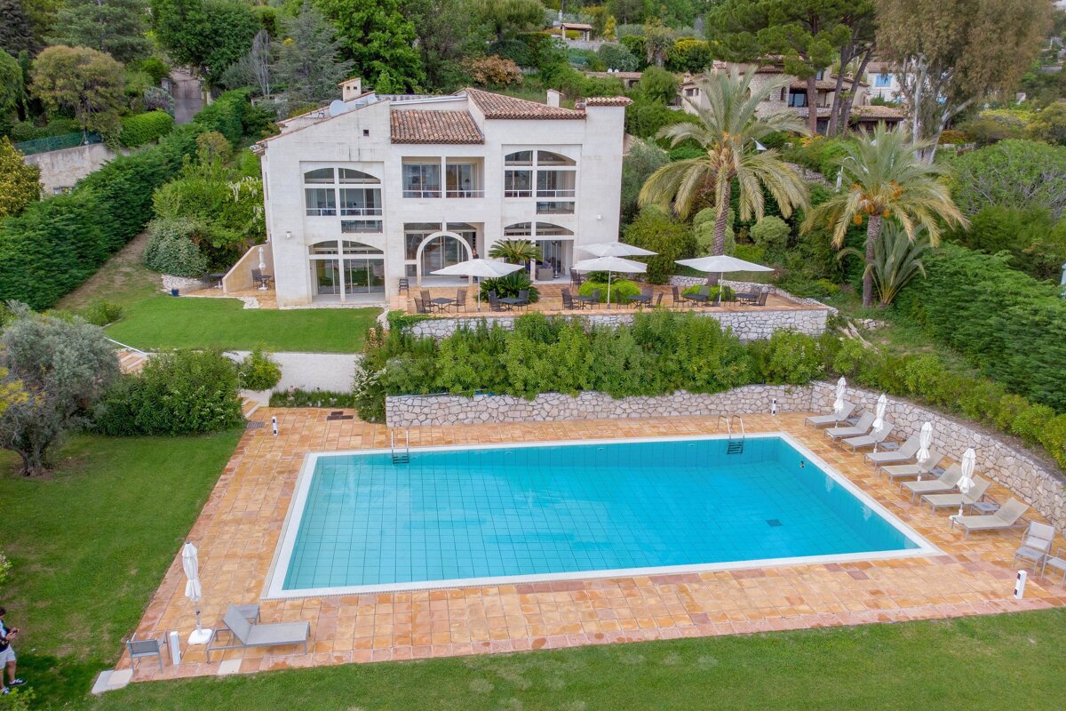 A large white house with a large swimming pool in front of it