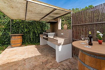 A bottle of wine sits on a table next to two glasses