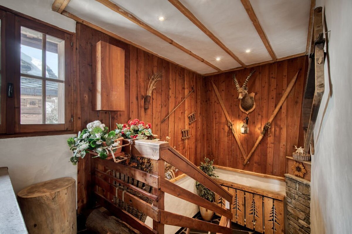 A wooden staircase with a deer head on the wall