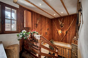 A wooden staircase with a deer head on the wall