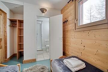 A bedroom with wooden walls and a toilet