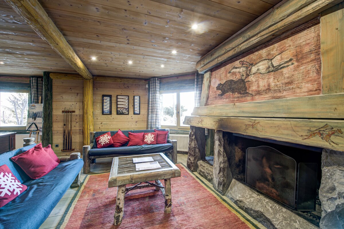 A living room with a fireplace and a painting on the wall