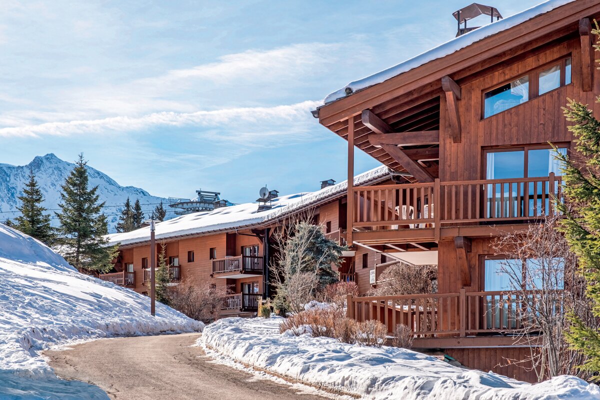 A snowy landscape with a ski lift in the background