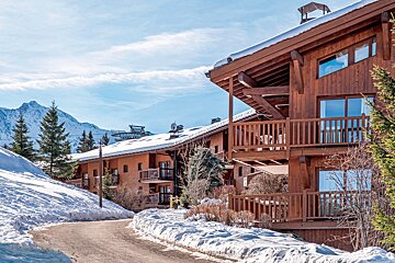 A snowy landscape with a ski lift in the background