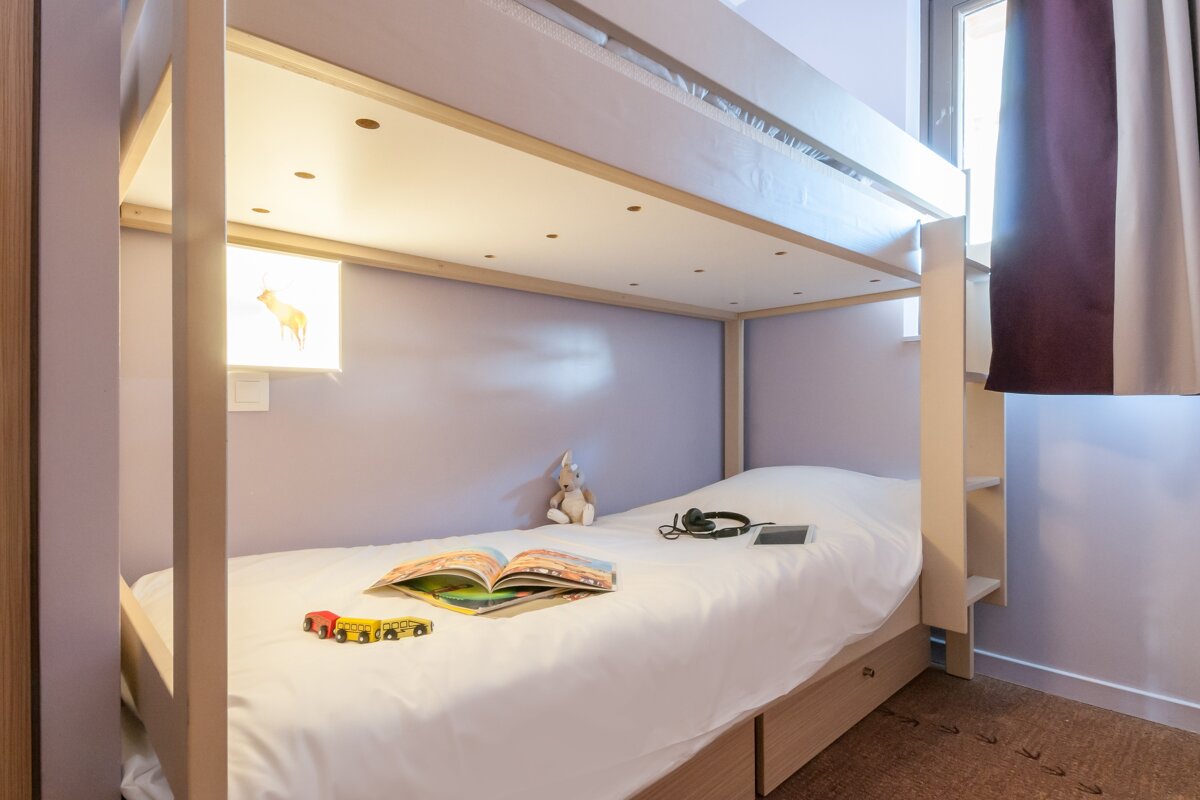 A bunk bed with a book and headphones on it