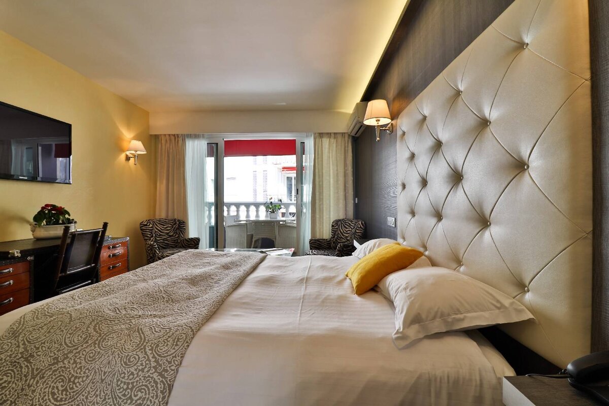 A hotel room with a large bed and a balcony