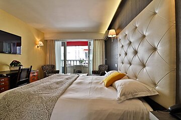 A hotel room with a large bed and a balcony