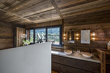A bathroom with wooden walls and two sinks
