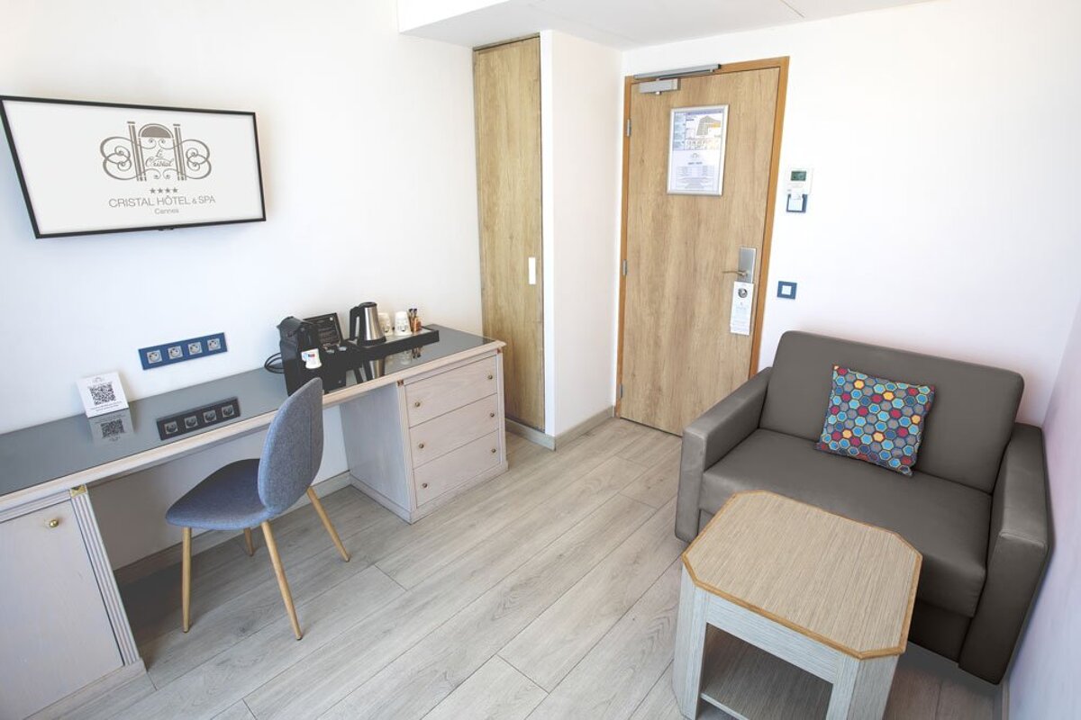 A hotel room with a couch and a desk