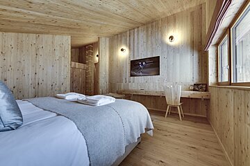 A bedroom with wooden walls and a large bed