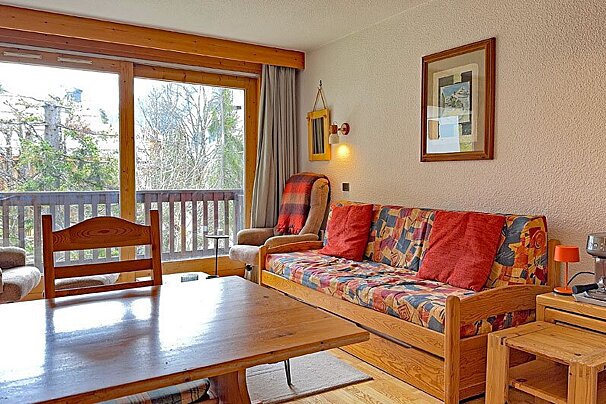A living room with a couch and chairs and a coffee maker