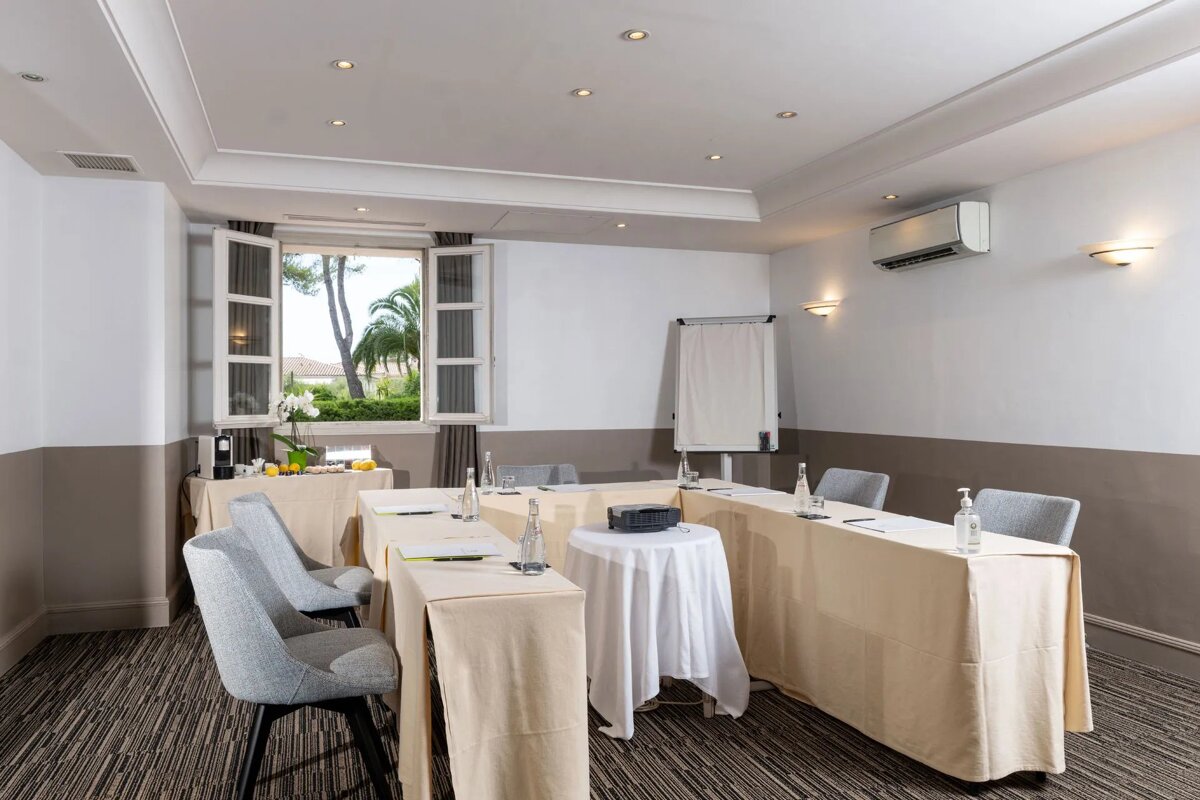 A conference room with tables and chairs set up in a u shape