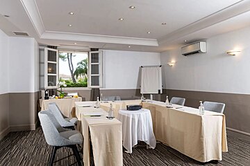 A conference room with tables and chairs set up in a u shape
