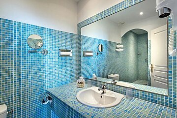 A bathroom with blue tiles and a sink