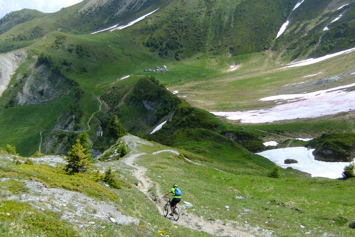 a mountain biker on a rocky little trails near some snow