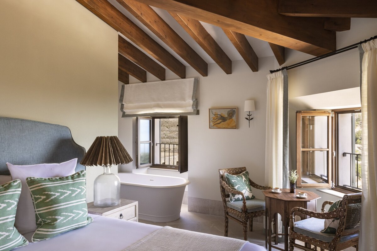 A bedroom with a bathtub and a table