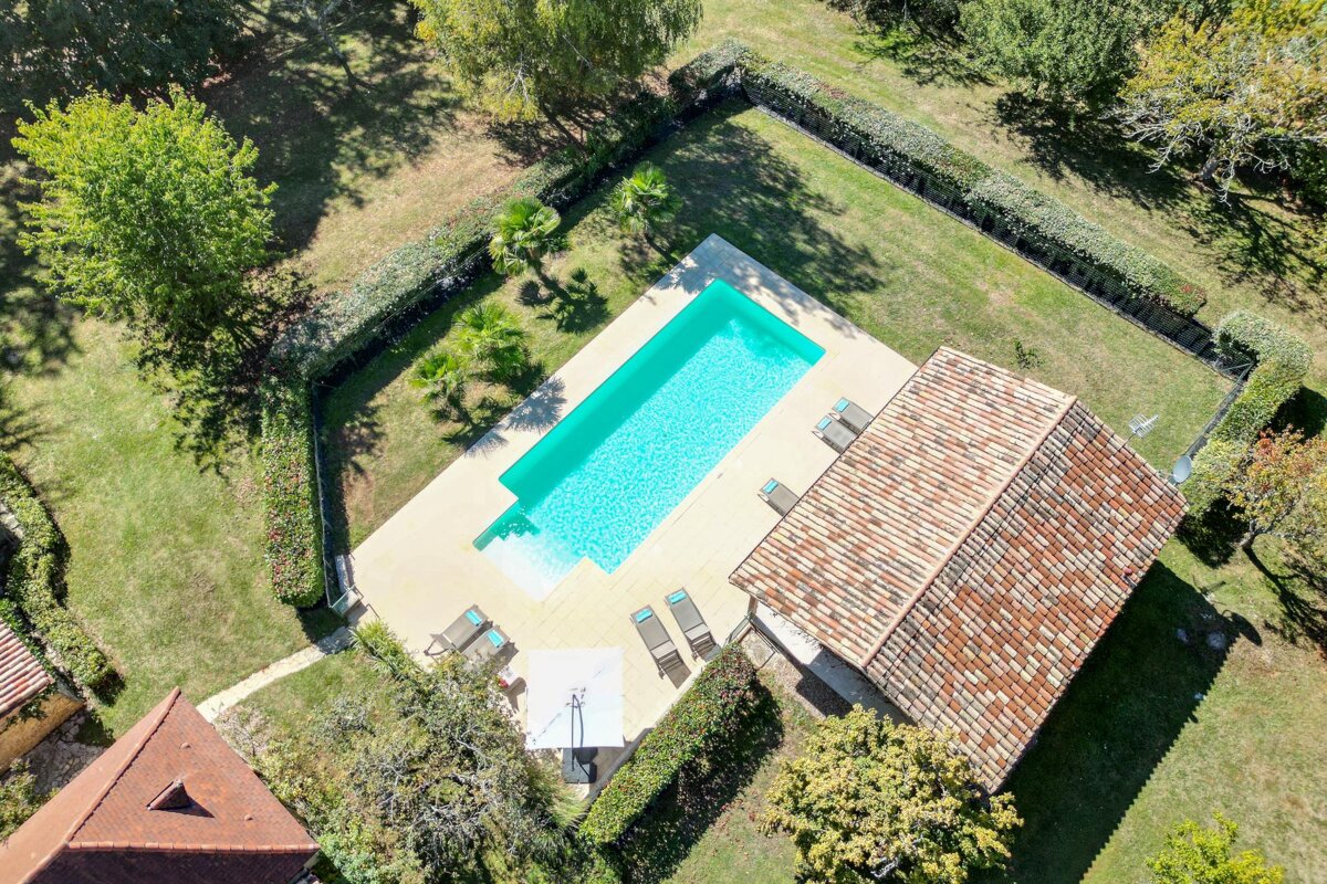 An aerial view of a house with a large swimming pool