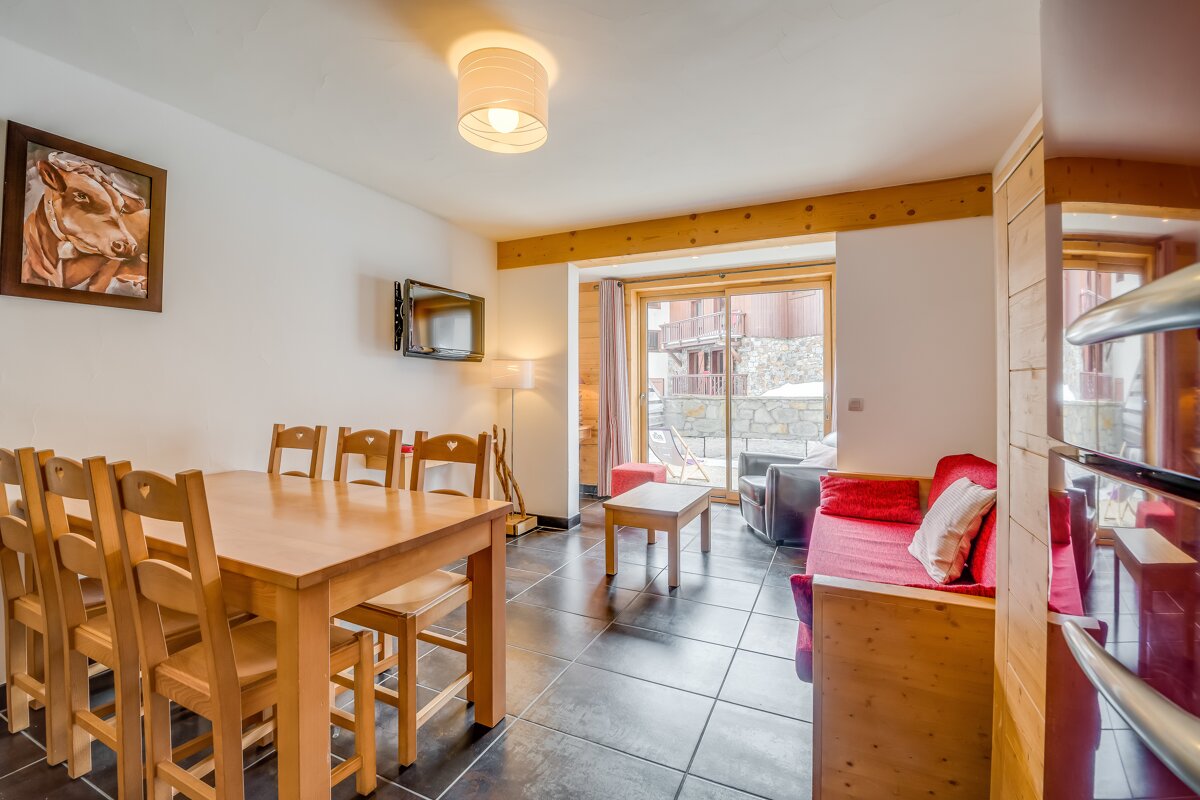 A living room with a table and chairs and a picture of a cow on the wall