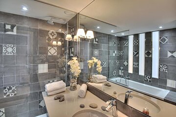 A bathroom with a large mirror and a bathtub