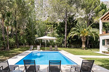 A large swimming pool surrounded by chairs and umbrellas