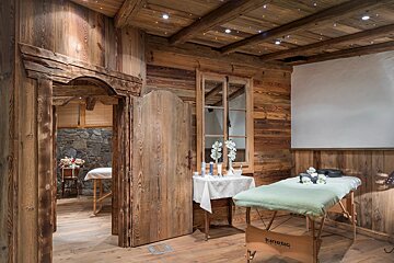 A wooden room with a massage table that says kinetic on it