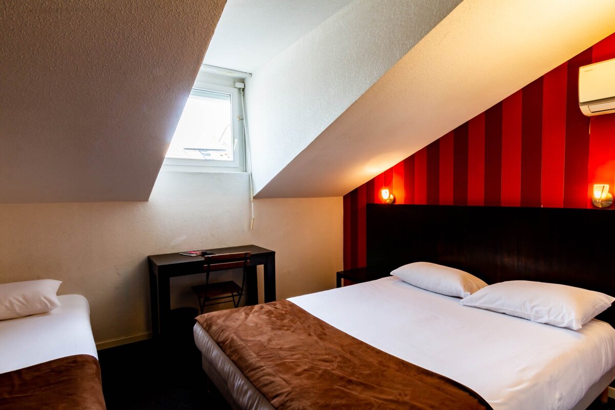 A hotel room with two beds and a desk