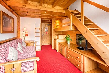 A living room with a wooden staircase and a couch