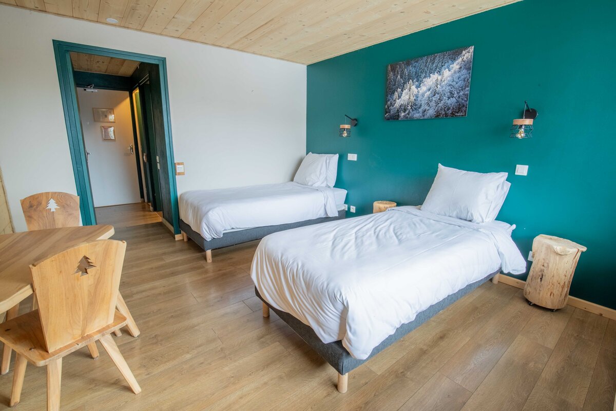 A bedroom with two beds and a table and chairs