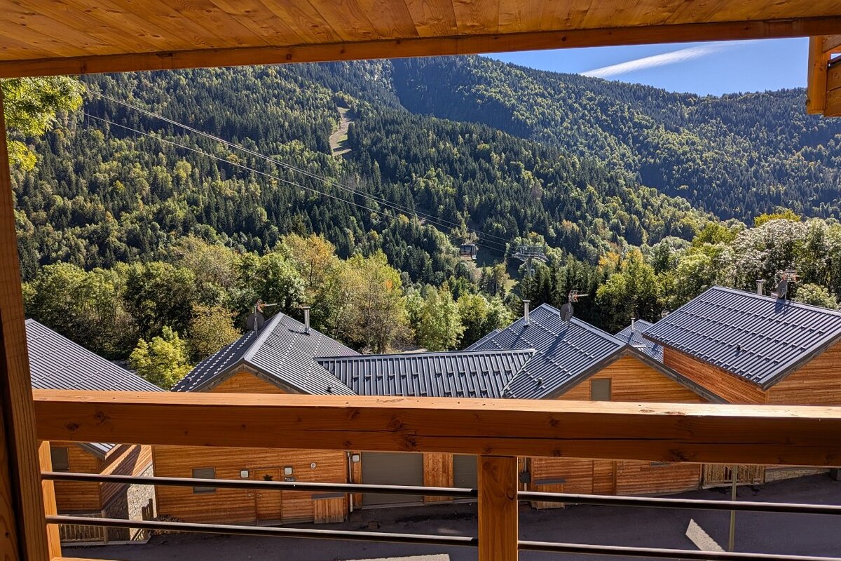 A balcony with a view of a mountain covered in trees