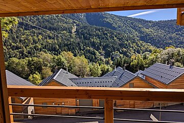A balcony with a view of a mountain covered in trees