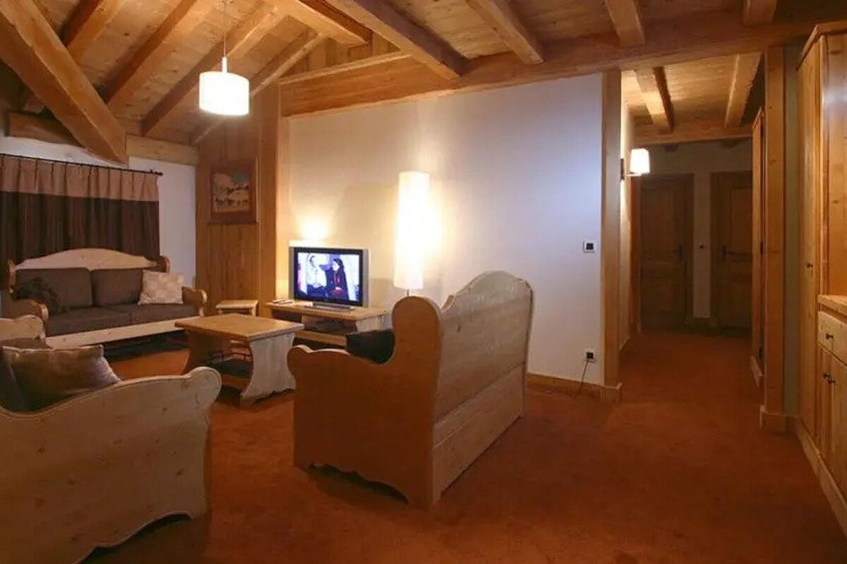 A living room with wooden furniture and a flat screen tv
