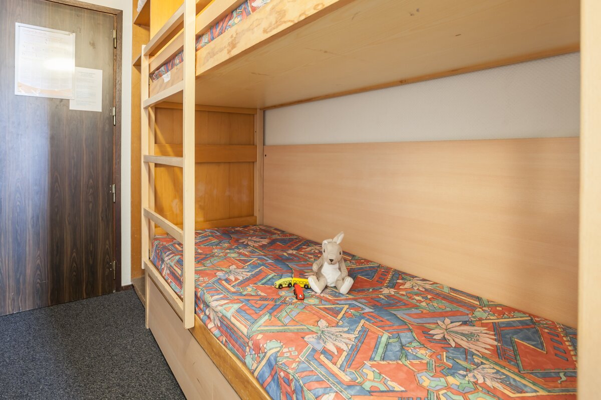 A stuffed kangaroo is sitting on a bunk bed