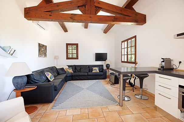 A living room with a black sectional couch and a flat screen tv