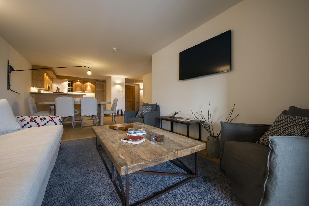 A living room with a wooden coffee table and a flat screen tv