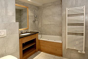 A bathroom with a bathtub and a towel rack