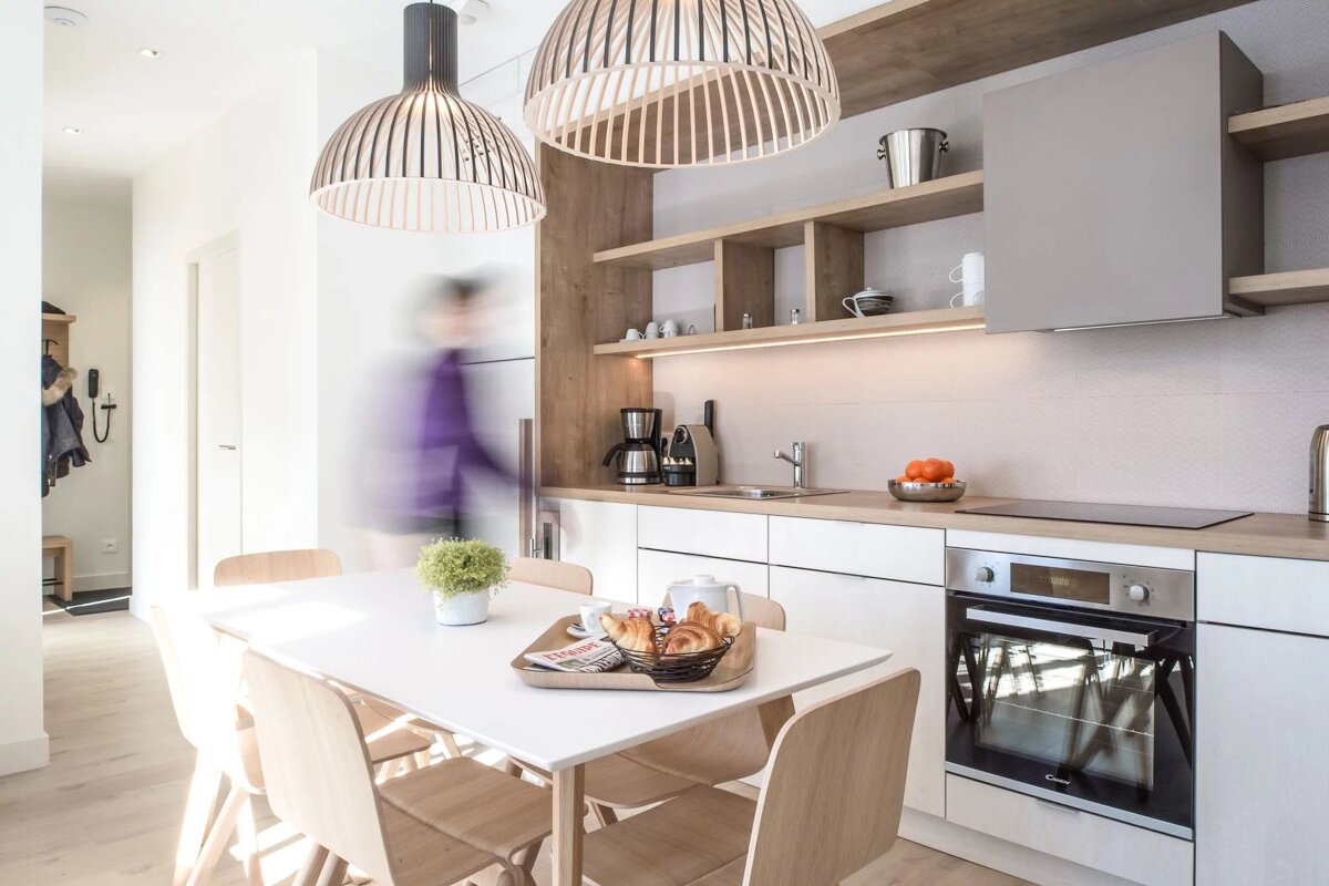 A kitchen with a table and chairs and a coffee maker