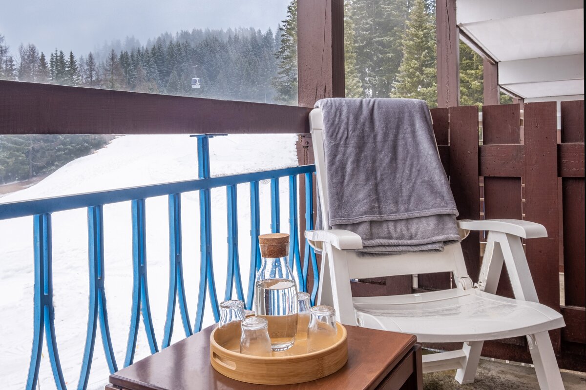 A bottle of water sits on a table next to a chair