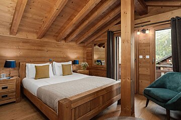 A bedroom with a wooden bed and a blue chair