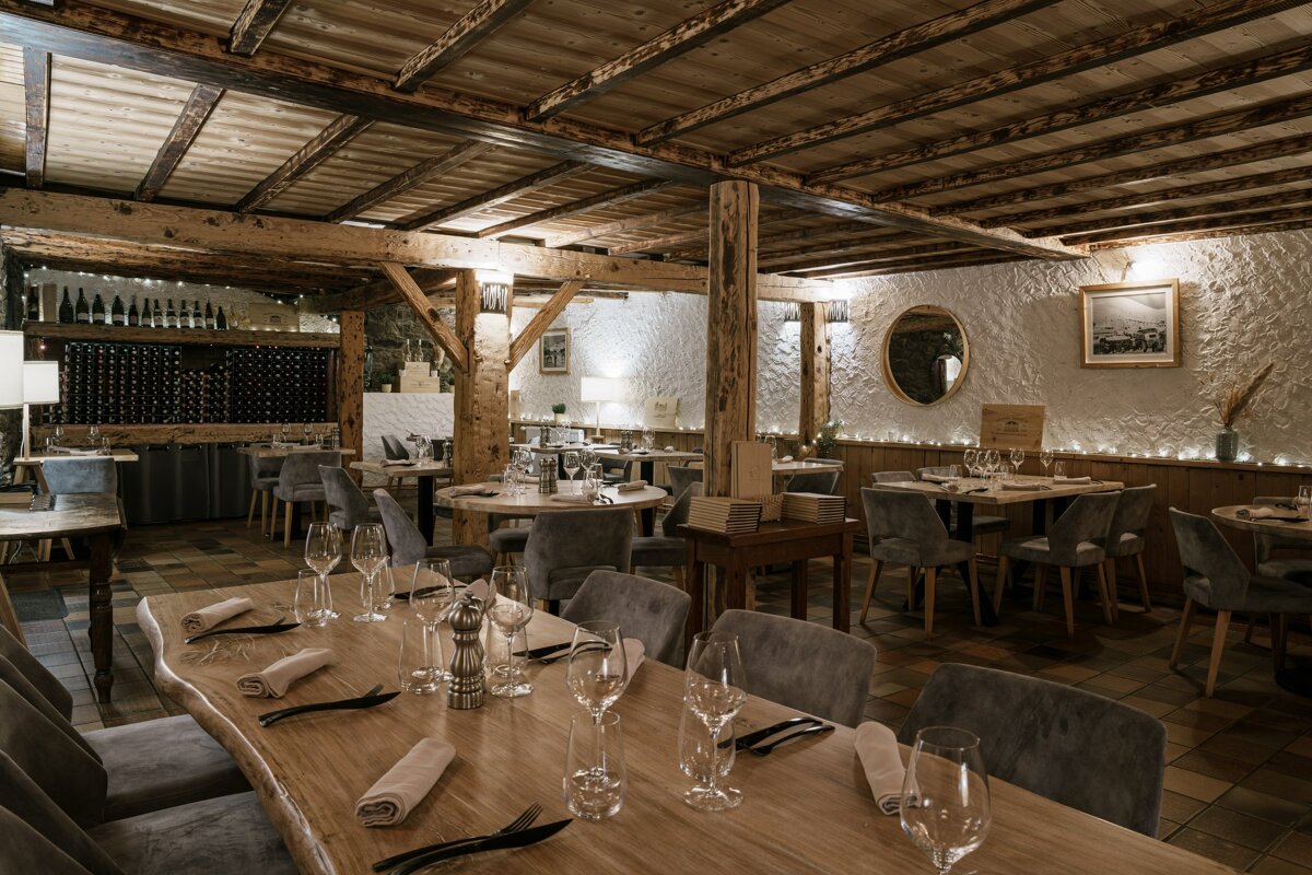 A dining room with tables and chairs set for a meal