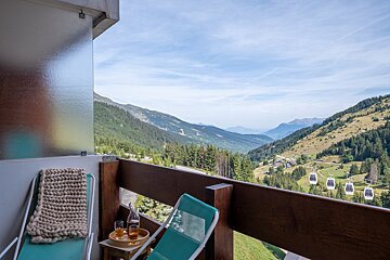 A balcony with a view of mountains and a ski lift
