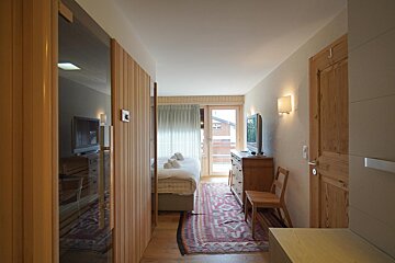 A bedroom with a large bed and a flat screen tv