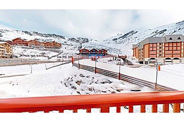 A view of a snowy ski resort from a balcony
