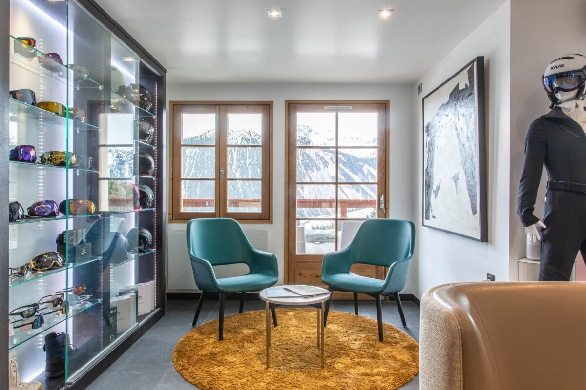 A room with two chairs and a table in front of a window