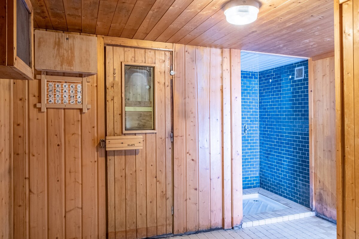 A wooden sauna with a sign that says 