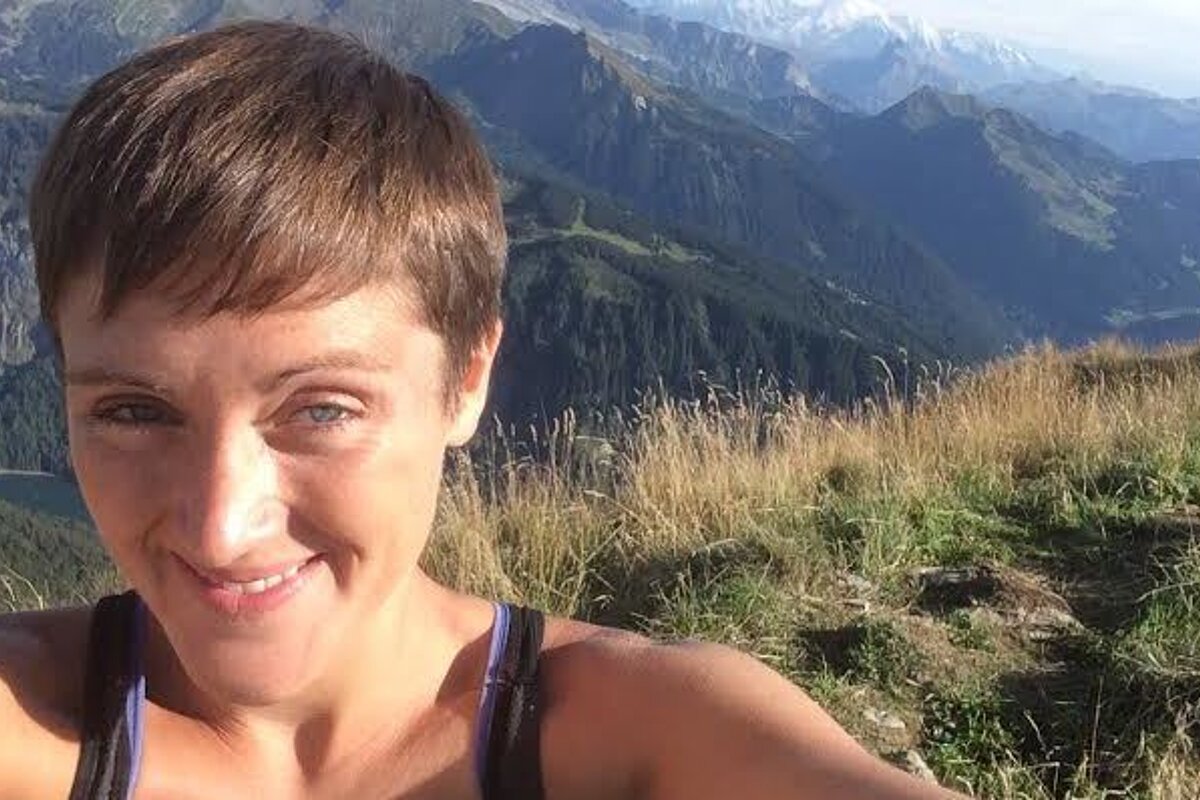 a woman with mountain views behind