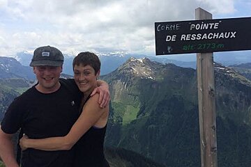 a couple embracing at the top of a mountain