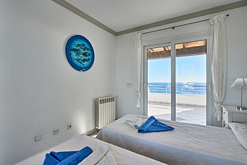 A bedroom with two beds and a painting on the wall