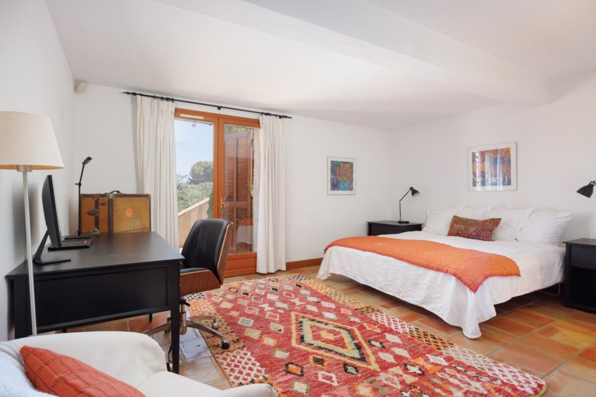 A bedroom with a large bed and a rug