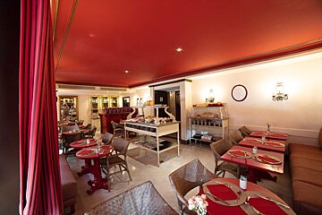 A restaurant with red tables and chairs and a red ceiling