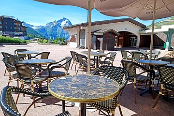 Tables and chairs under an umbrella that says coca cola